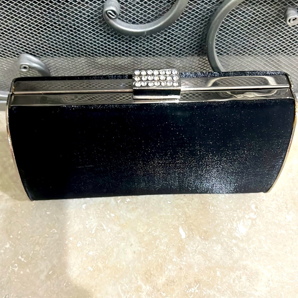 Black satin clutch with rhinestone clasp and silver chain.